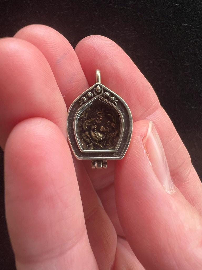 Tiny Dzambhala Ghau Pendant | Metal and Glass | Approx 3/4in x 1/2in | Tibet | Gau