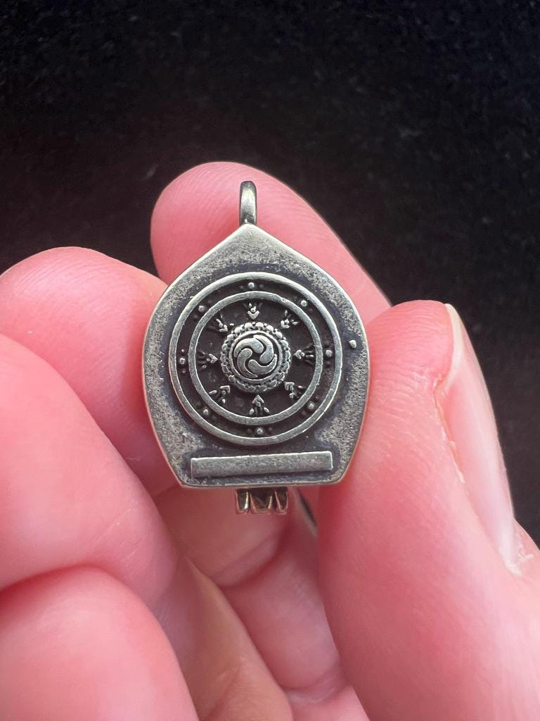 Tiny Dzambhala Ghau Pendant | Metal and Glass | Approx 3/4in x 1/2in | Tibet | Gau