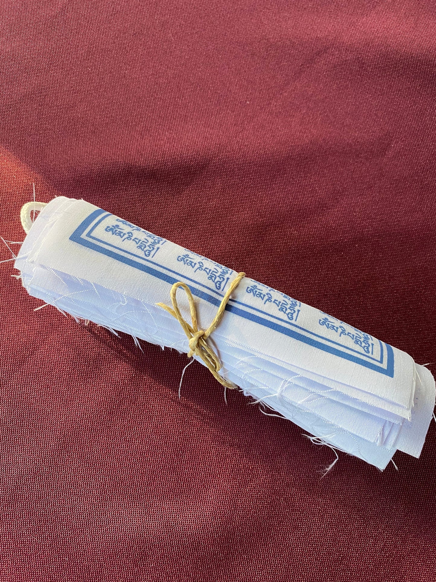 A close of of one roll of 10 all white 1000 Armed Chenrezig flags imprinted in blue on a medium background. Uplifting and beautiful.