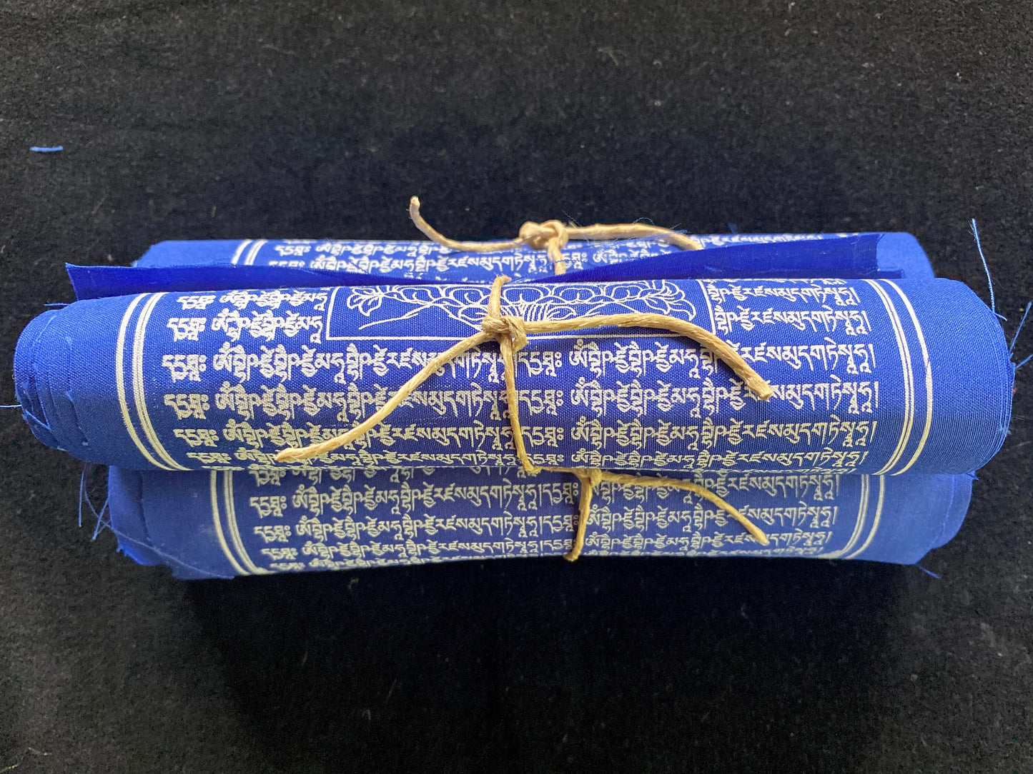 3 rolls of 10 blue Medicine Buddha Tibetan prayer flags, 6x7.5 inch, imprinted with Lord of Lapis Lazuli Light stacked on a black background