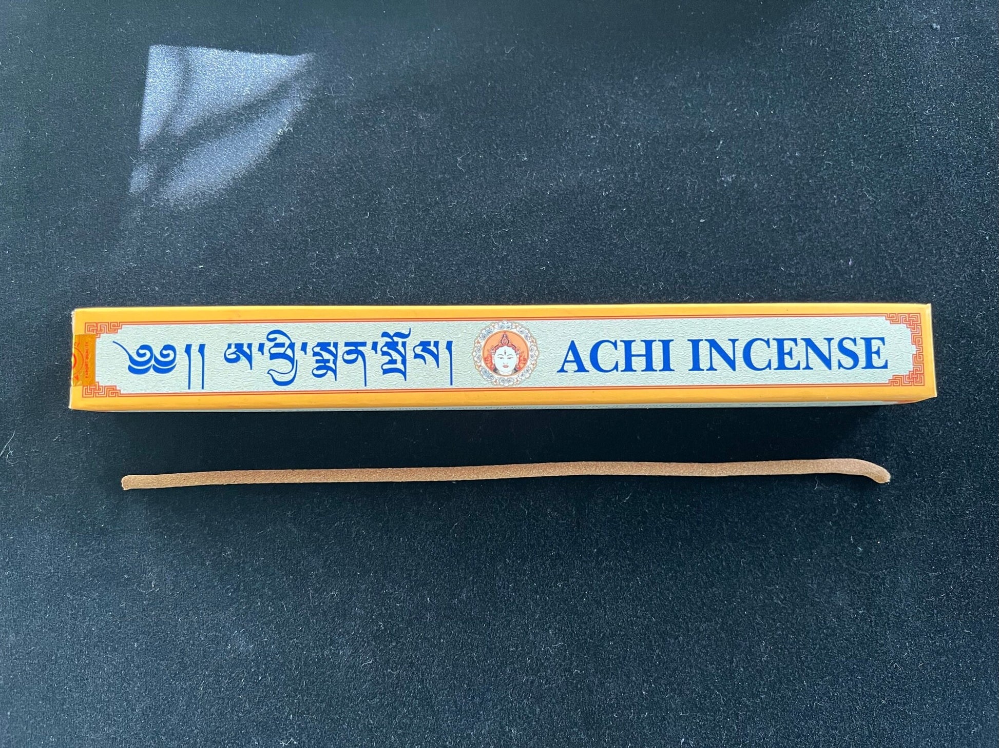 Achi Incense box with one stick on black velvet. Try our specialty incense for an enhanced meditation experience.