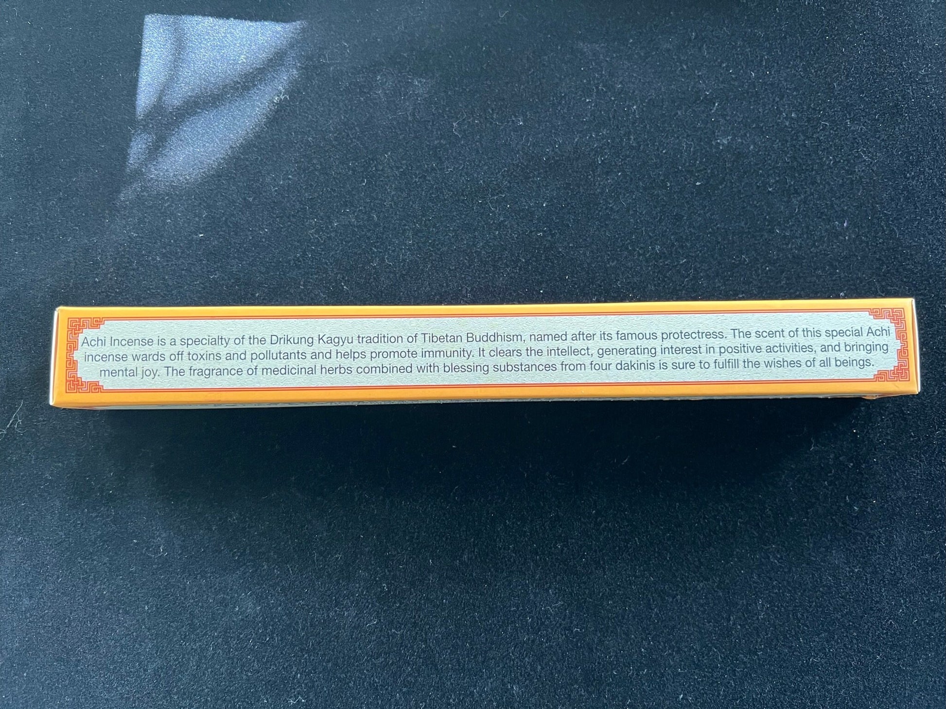 Back of Achi Incense box with product description on black velvet. Learn about the benefits of our specialty incense and try it for an enhanced meditation experience.