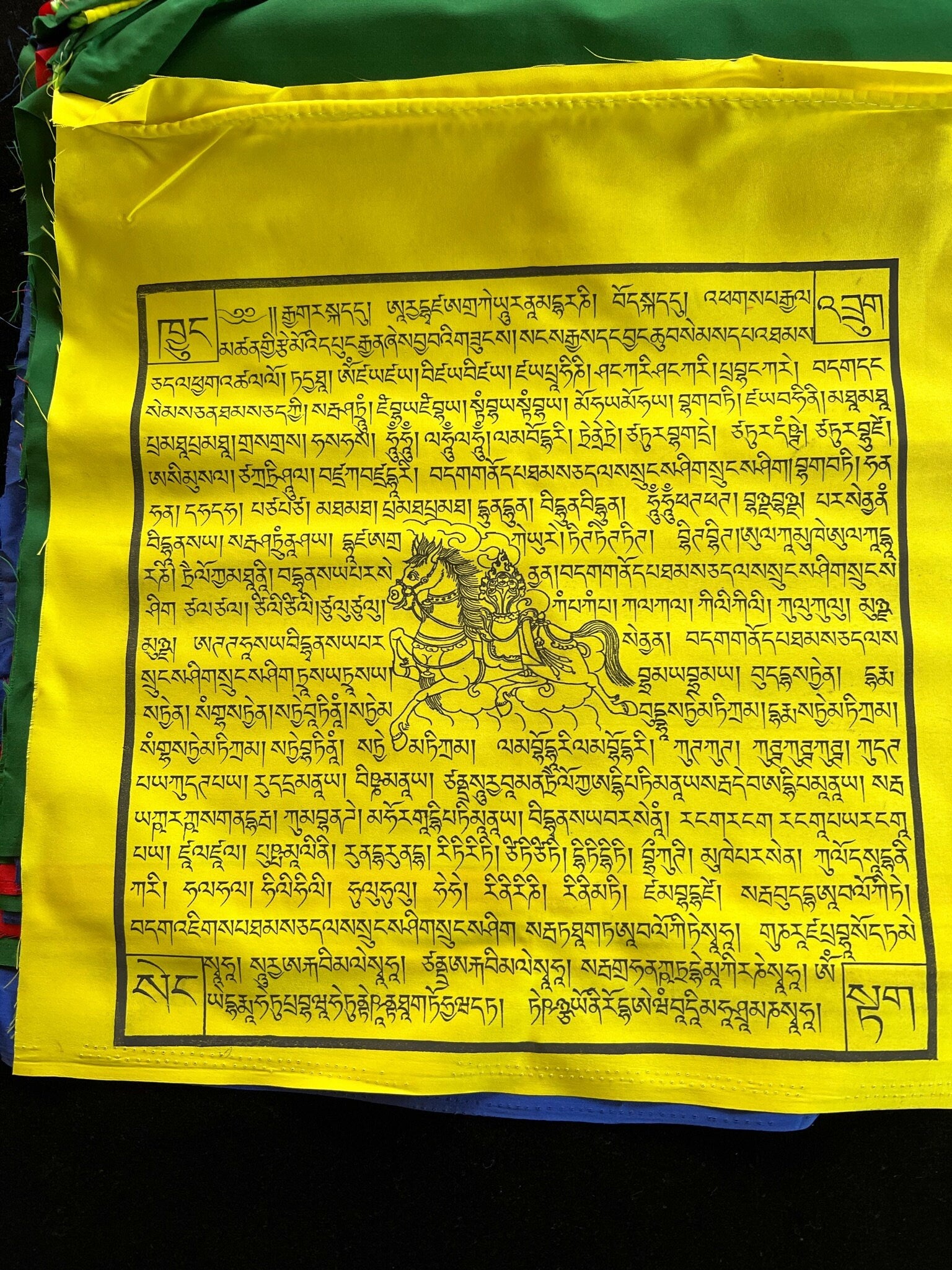 a single yellow flag from a Set of 25 Tibetan prayer flags with Gyaltsen Tsenmö prayers and windhorse designs on 13x13 inch flags in 5 colors. Believed to bring success to virtuous endeavors.