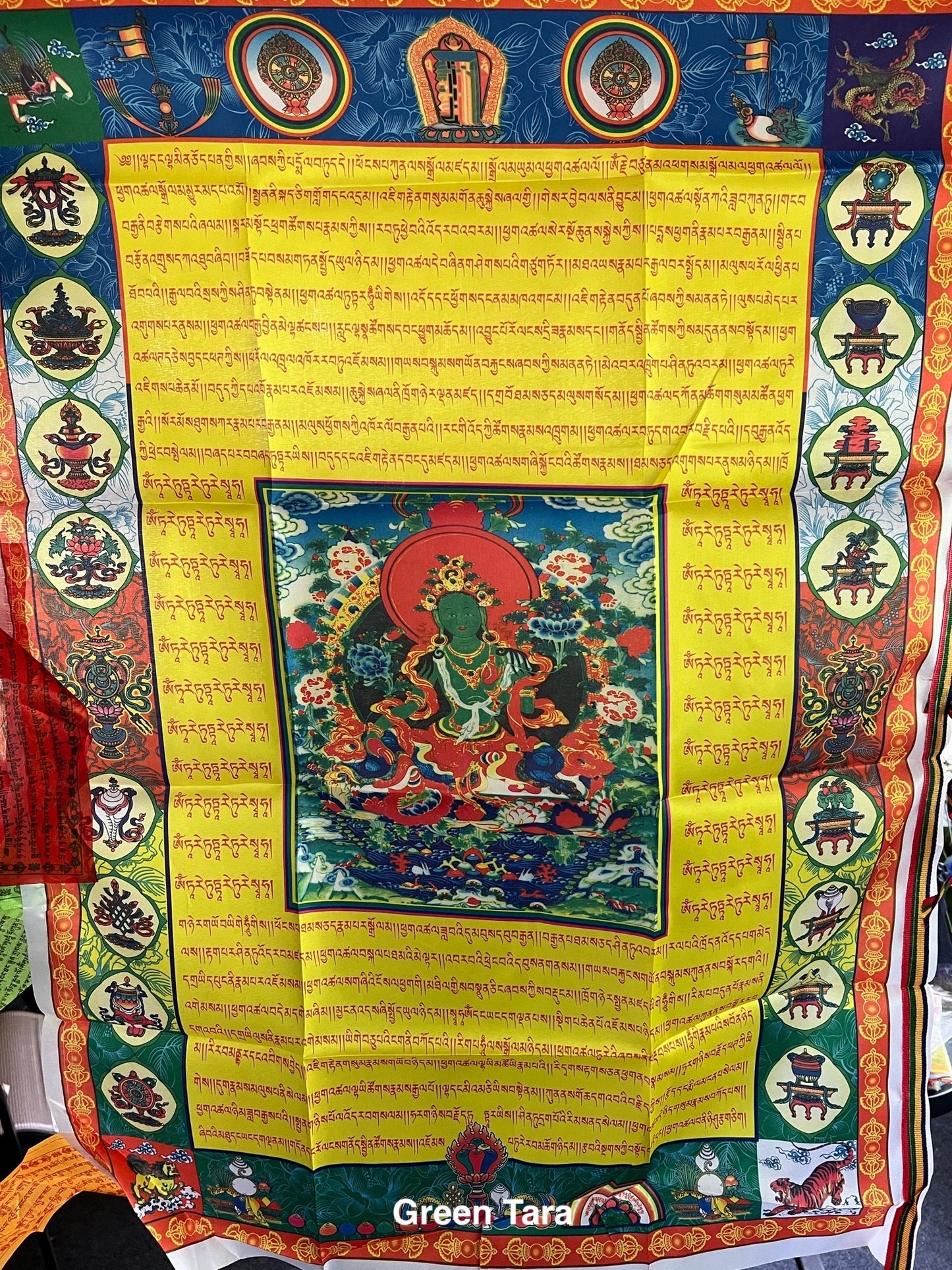 Green Tara Tibetan Prayer Banner: High-quality poly silk flag imprinted with the revered female Buddha Green Tara. Measures 27x39 inches, suitable for hanging on a pole or a wall
